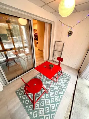 a red table and a chair in a room at Loft jacuzzi à 8 min des Grands Buffets et du centre-ville in Narbonne