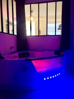 a bathroom with a bath tub with a red light at Loft jacuzzi à 8 min des Grands Buffets et du centre-ville in Narbonne