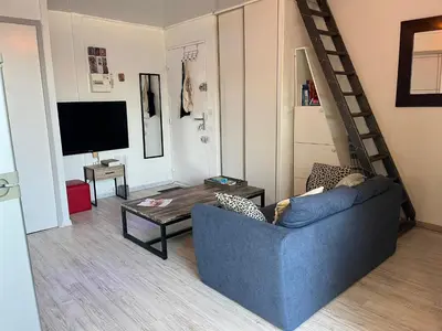 a living room with a blue couch and a tv at Gruissan : T2 Climat. et Parking Proche Village - FR-1-796-96 in Gruissan
