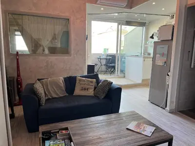 a living room with a couch and a table at Gruissan : T2 Climat. et Parking Proche Village - FR-1-796-96 in Gruissan