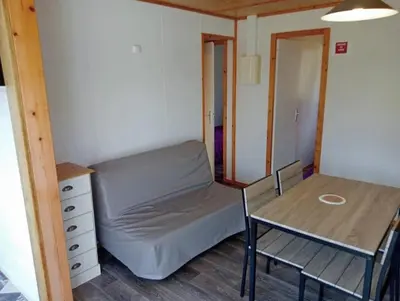 a dining room with a table and a pink couch at Camping 3 étoiles - Piscine - ccbeed0 in Mazères