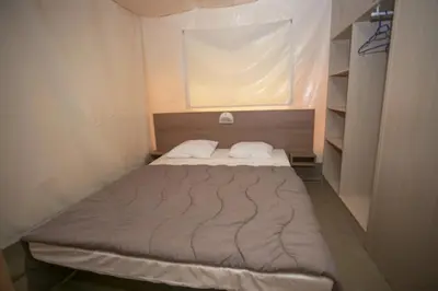 a purple bed with blue pillows in a room at Camping 3 étoiles - Piscine - ccbeed0 in Mazères