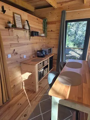 a kitchen in a log cabin with a table and chairs at La parenthèse in Ansignan