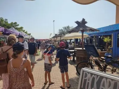a group of people walking down a street at Studio à 50m de la Plage du Grazel avec Parking - FR-1-796-104 in Gruissan