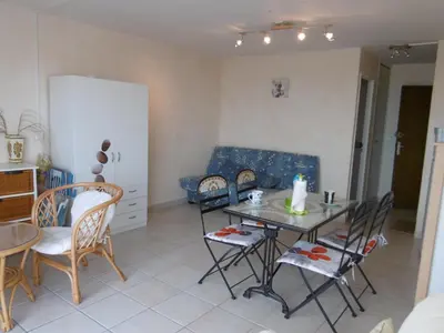 a living room with a white couch and a table at Studio à 50m de la Plage du Grazel avec Parking - FR-1-796-104 in Gruissan