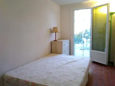 a bedroom with a bed and a sliding glass door at Villa T4 8 pers proche plage Grazel, parking privé et terrasse - FR-1-796-98 in Gruissan