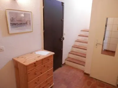 a hallway with a door and a dresser and stairs at Villa T4 8 pers proche plage Grazel, parking privé et terrasse - FR-1-796-98 in Gruissan