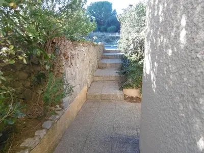 a stone wall with stairs next to a wall at Villa T4 8 pers proche plage Grazel, parking privé et terrasse - FR-1-796-98 in Gruissan