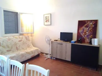 a living room with a couch and a tv at Villa T4 8 pers proche plage Grazel, parking privé et terrasse - FR-1-796-98 in Gruissan