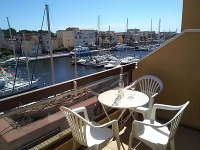 a table and chairs on a balcony with a harbor at Studio Coquet 2/3 Pers au Cœur de Gruissan - FR-1-796-99 in Gruissan