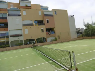 a tennis court in front of a building at Studio Coquet 2/3 Pers au Cœur de Gruissan - FR-1-796-99 in Gruissan