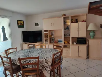 a dining room with a table and chairs and a television at Villa T4 Gruissan avec Vue Mer, Climatisée, 80m2, Plage à 50m, 6 Pers. - FR-1-796-100 in Gruissan