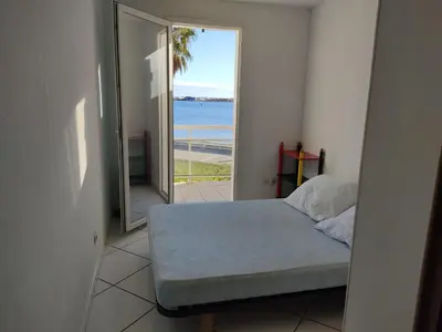 a bedroom with a bed and a view of the ocean at Villa T4 Gruissan avec Vue Mer, Climatisée, 80m2, Plage à 50m, 6 Pers. - FR-1-796-100 in Gruissan