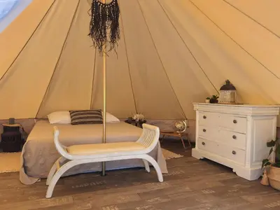 a bedroom with a bed and a dresser in a tent at Tente Out of Africa in Alzonne