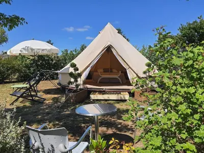 a tent with a table and chairs in a yard at Tente Out of Africa in Alzonne