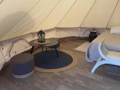 a tent with a table and a chair in it at Tente Out of Africa in Alzonne