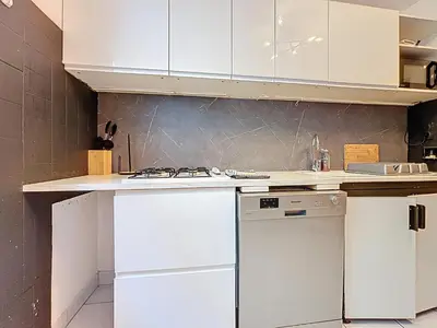 a kitchen with white cabinets and a dishwasher at Le Brooklyn - Appartement rez de chaussée - Wifi in Narbonne