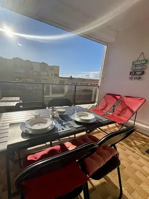 a table and chairs on a balcony with a view at Studio sur le port avec piscine & terrasse in Gruissan