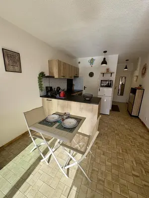 a kitchen with a table and a counter top at Studio sur le port avec piscine & terrasse in Gruissan