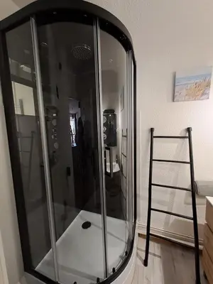 a glass shower in a room with a ladder at Studio sur le port avec piscine & terrasse in Gruissan