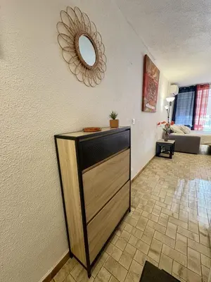 a room with a dresser with a mirror on the wall at Studio sur le port avec piscine & terrasse in Gruissan