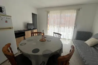 a kitchen with a table and a couch in a room at Nice Apt close to the beaches of Port-la-Nouvelle in Port-la-Nouvelle