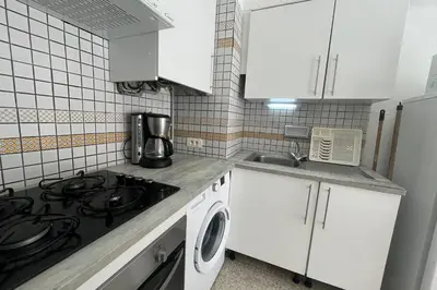 a kitchen with white cabinets and a stove top oven at Nice Apt close to the beaches of Port-la-Nouvelle in Port-la-Nouvelle