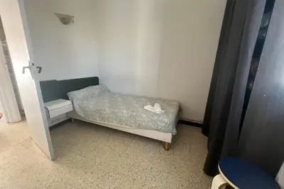 a small room with a bed and a chair at Nice Apt close to the beaches of Port-la-Nouvelle in Port-la-Nouvelle