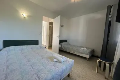 a bedroom with a bed and a chair in it at Nice Apt close to the beaches of Port-la-Nouvelle in Port-la-Nouvelle