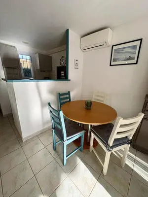 a kitchen and dining room with a table and chairs at Pavillon avec piscine à deux pas de la plage in Gruissan