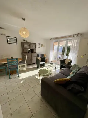 a living room with a couch and a table at Pavillon avec piscine à deux pas de la plage in Gruissan