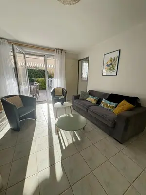 a living room with a couch and a table at Pavillon avec piscine à deux pas de la plage in Gruissan