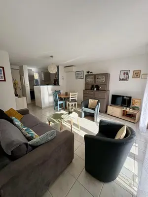 a living room with a couch and chairs at Pavillon avec piscine à deux pas de la plage in Gruissan