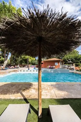 a large umbrella sitting next to a swimming pool at Camping La Tour de France in Latour-de-France