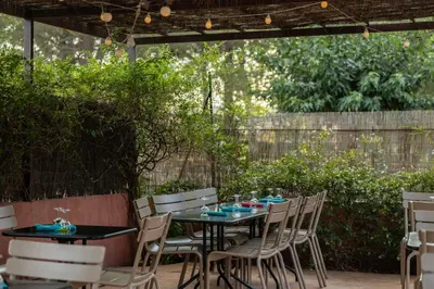 a patio with a table and chairs under a pergola at Camping La Tour de France in Latour-de-France