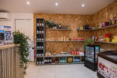a wine shop with a shelf of wine bottles at Camping La Tour de France in Latour-de-France