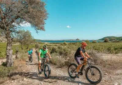a group of people riding bikes on a dirt road at Le Petit Grazel in Gruissan