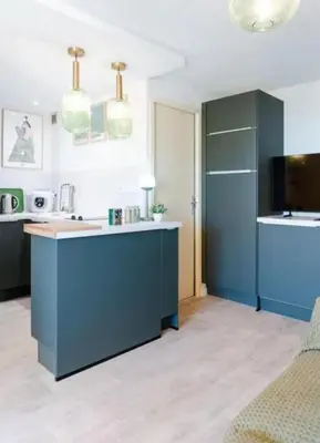 a kitchen with blue cabinets and a counter top at Le Petit Grazel in Gruissan