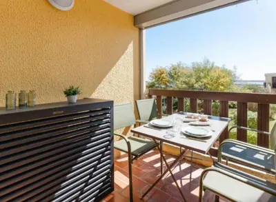 a patio with a table and chairs on a balcony at Le Petit Grazel in Gruissan