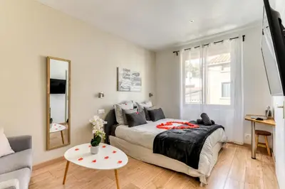 a bedroom with a bed and a couch and a table at Le Bourget - Suite et Envolée romantique avec Jacuzzi in Narbonne
