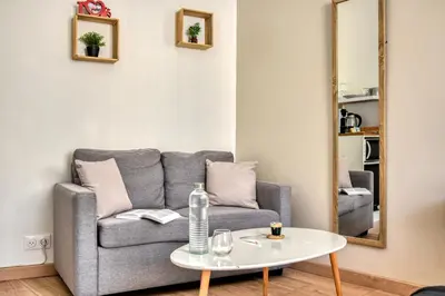 a living room with a couch and a table at Le Bourget - Suite et Envolée romantique avec Jacuzzi in Narbonne