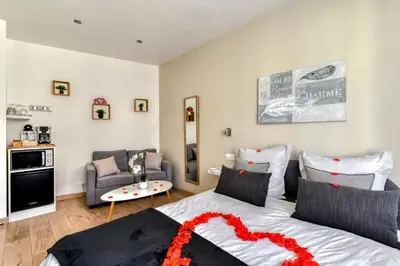 a bedroom with a bed and a living room at Le Bourget - Suite et Envolée romantique avec Jacuzzi in Narbonne