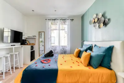 a bedroom with a large bed with colorful pillows at Le Bourget - Suite et Envolée romantique avec Jacuzzi in Narbonne