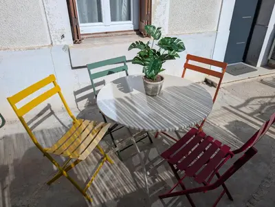 a table with four chairs and a potted plant on it at Kavi-T3 Cozy - Medieval City 4 min - Air-Conditioning-Parking in Carcassonne