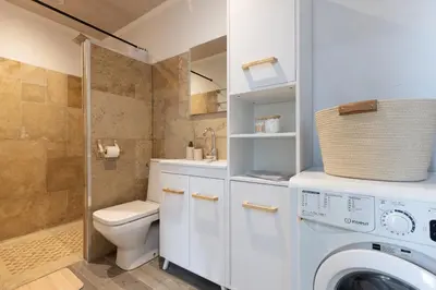 a bathroom with a toilet and a washing machine at Kavi-T3 Cozy - Medieval City 4 min - Air-Conditioning-Parking in Carcassonne