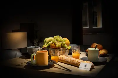 a table with a breakfast of bread and fruit and orange juice at Kavi-T3 Cozy - Medieval City 4 min - Air-Conditioning-Parking in Carcassonne
