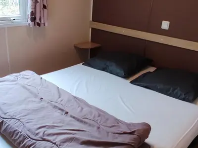 a bed with two pillows on it in a room at Mobil-home 6 Pers avec Terrasse à Axat - API-1-52-973 in Axat