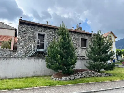 two trees in front of a stone house at MCC House, cozy accommodation with terrace and BBQ in Quillan
