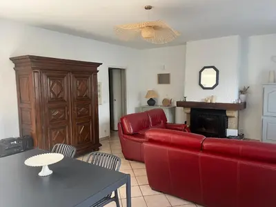 a living room with a red couch and a fireplace at MCC House, cozy accommodation with terrace and BBQ in Quillan