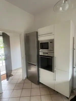 a kitchen with a stainless steel refrigerator and a microwave at MCC House, cozy accommodation with terrace and BBQ in Quillan